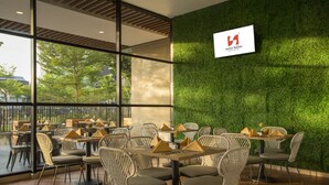 Un restaurante con mesas en el interior, una pared verde y un letrero de Swiss-Bellinn.