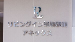 A metallic sign with a large 'R' and Japanese characters.