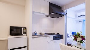 A compact kitchen with a microwave, stove, and dishwasher.
