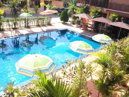 Una piscina al aire libre, sillones reclinables de piscina