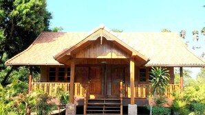A wooden house with a porch and steps leading to the entrance.