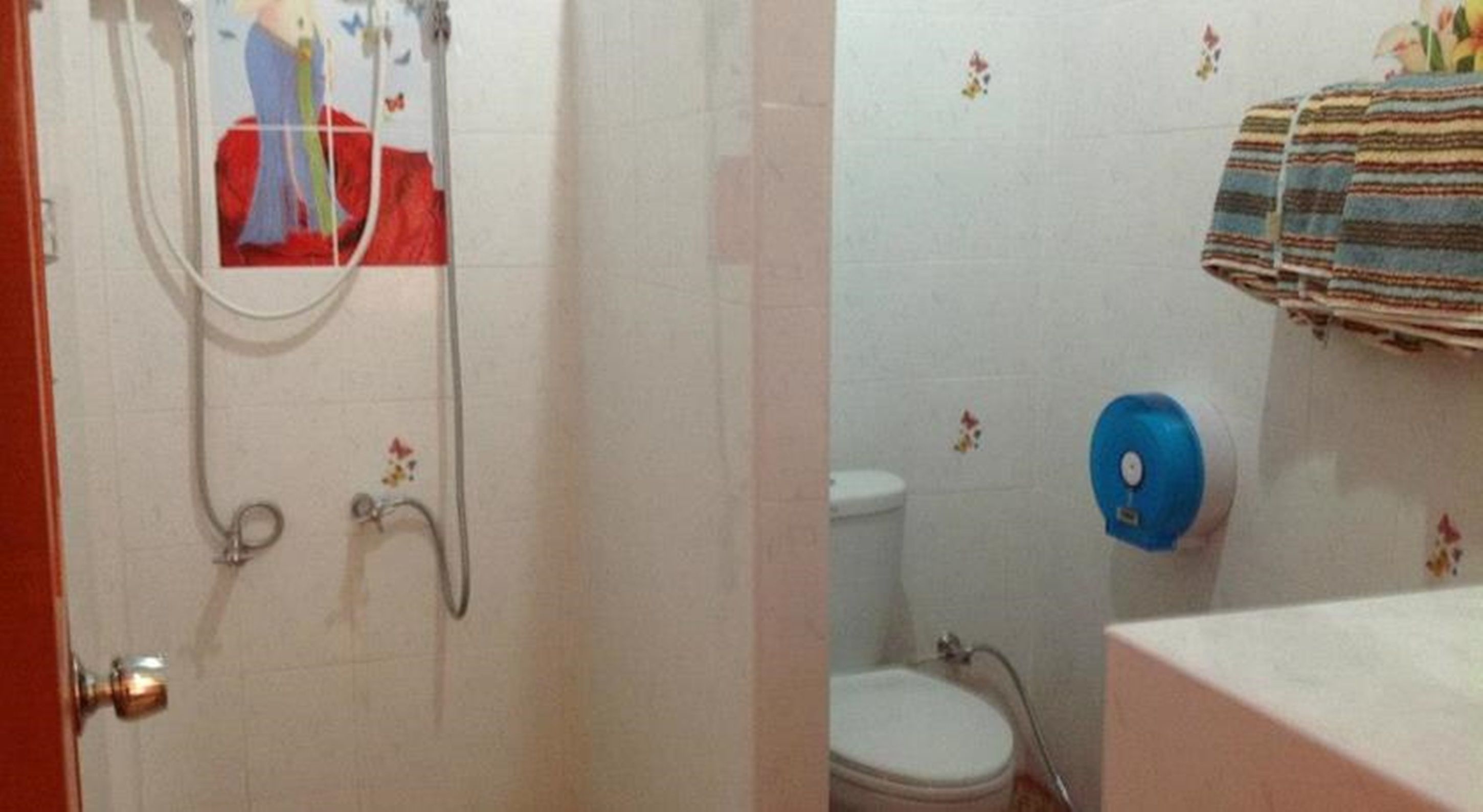 A bathroom with a shower, toilet, and a towel rack.