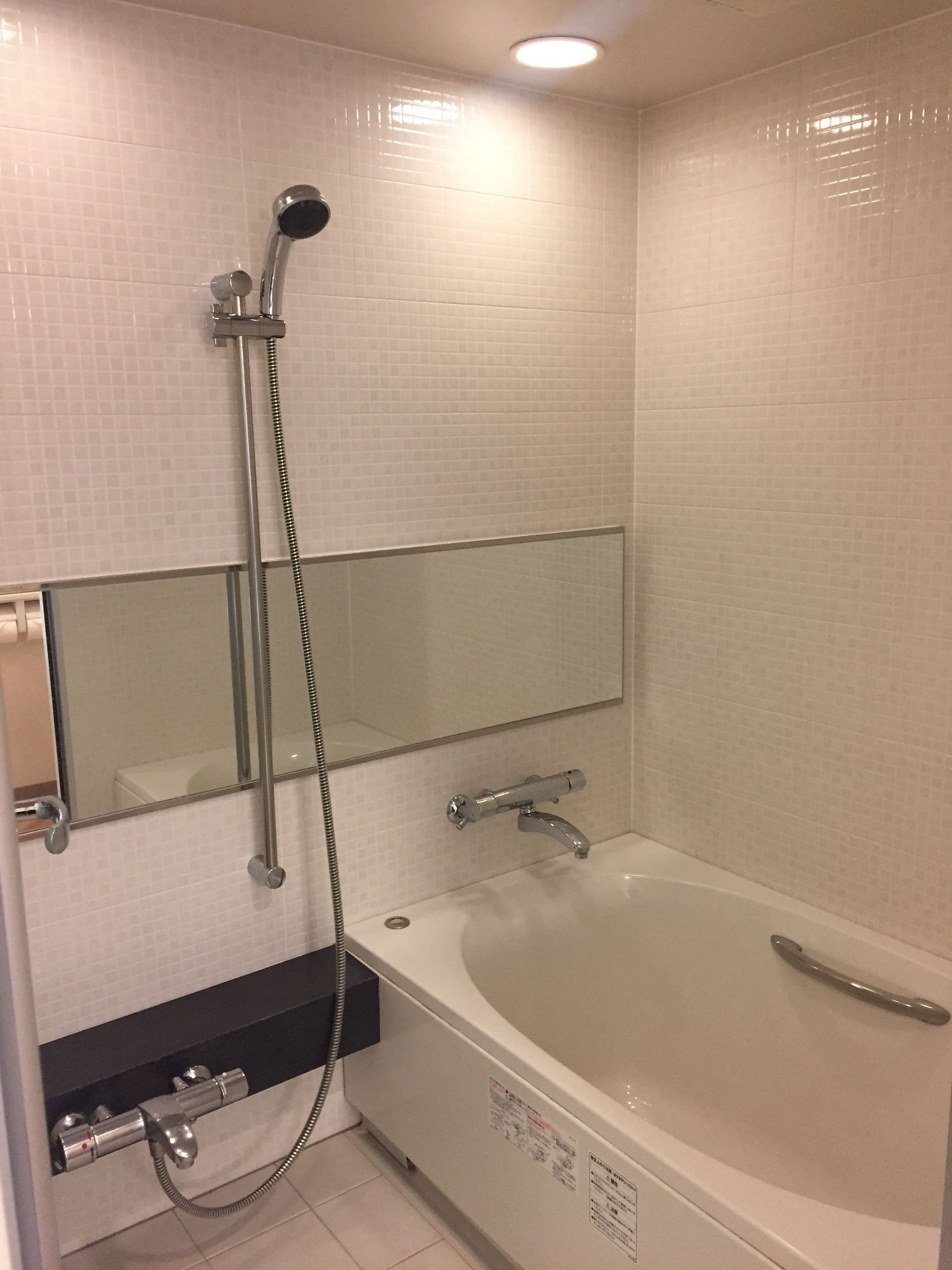 Un baño con bañera, ducha y espejo.