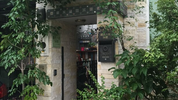 A traditional Japanese-style entrance with a stone gate, a small shop, and potted plants. - Hualien Paris Home B&B (Hualien City)