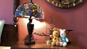 A wooden cabinet with a stained glass lamp, two teddy bears, and a mirror on the wall. - Hualien Paris Home B&B (Hualien City)
