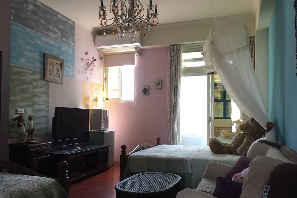 Una sala de estar acogedora con una televisión, una mesita y un sofá.