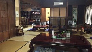 A traditional Japanese-style room with tatami flooring, a low wooden table, and cushions. - Wakayama Guest House Shido (Hashimoto)