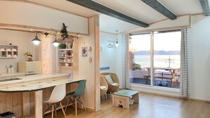 Una cocina acogedora con armarios de madera, un comedor con sillas y un amplio ventanal con vistas panorámicas.