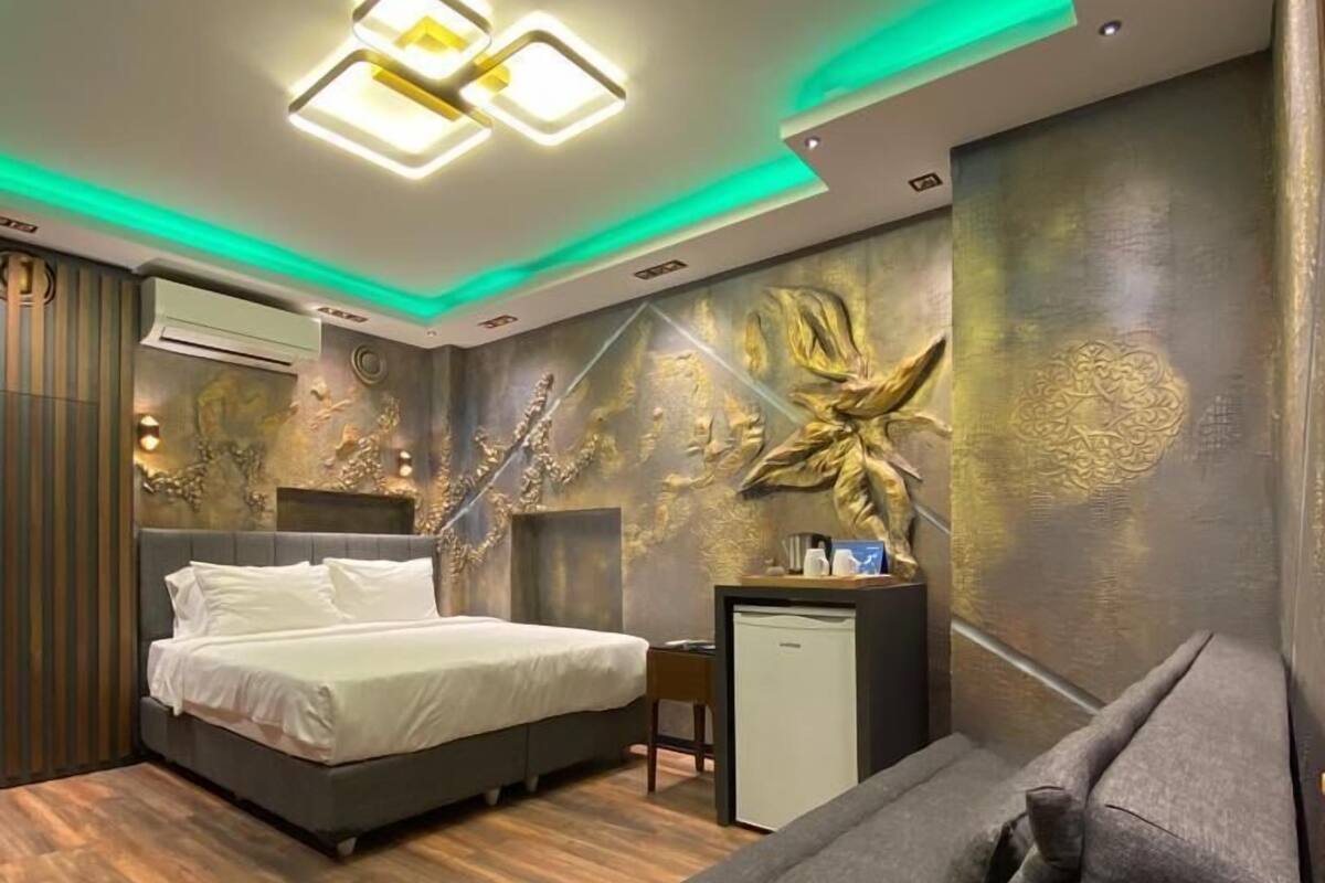Una habitación de hotel moderna con una cama, un sofá y un escritorio.