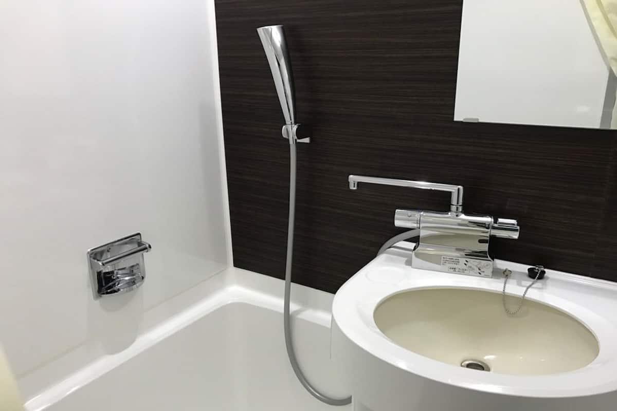 Ensemble baignoire-douche, séchoir à cheveux, pantoufles, bidet