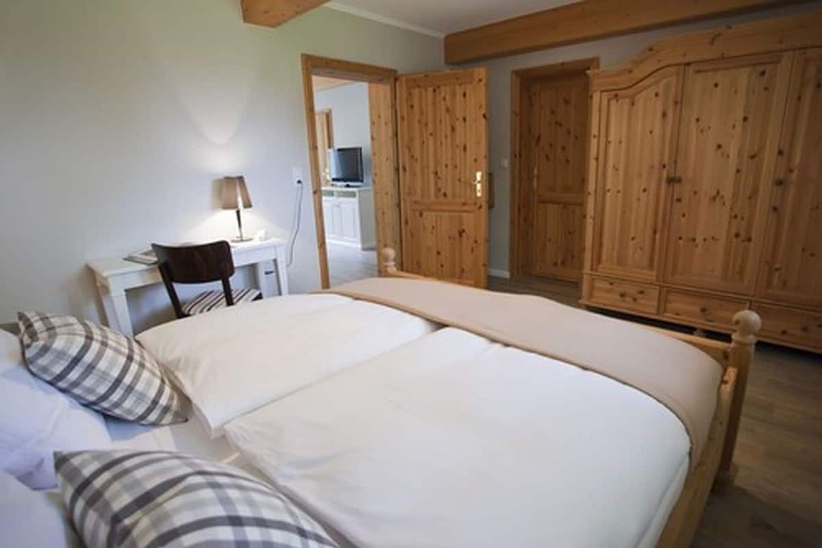 Un dormitorio con cama, escritorio y armarios de madera.