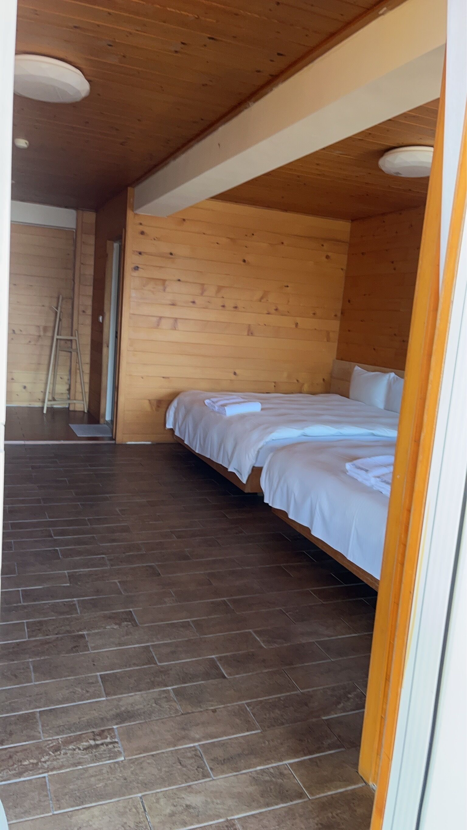 Une pièce en bois avec un lit, une échelle et un sol carrelé.