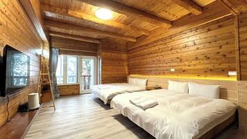 A wooden cabin with two beds, a television, and a balcony.