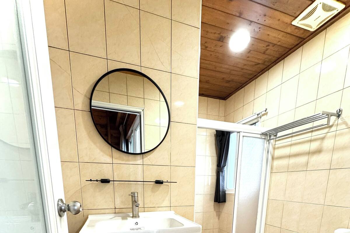 A bathroom with a sink, mirror, toilet, and shower.
