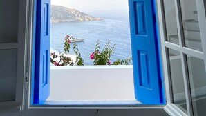 An open window with a view of the sea and a boat. - Petradi Hotel (Ios)