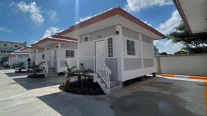 Un edificio moderno con techo plano, paredes exteriores blancas y una escalera que conduce a la entrada.