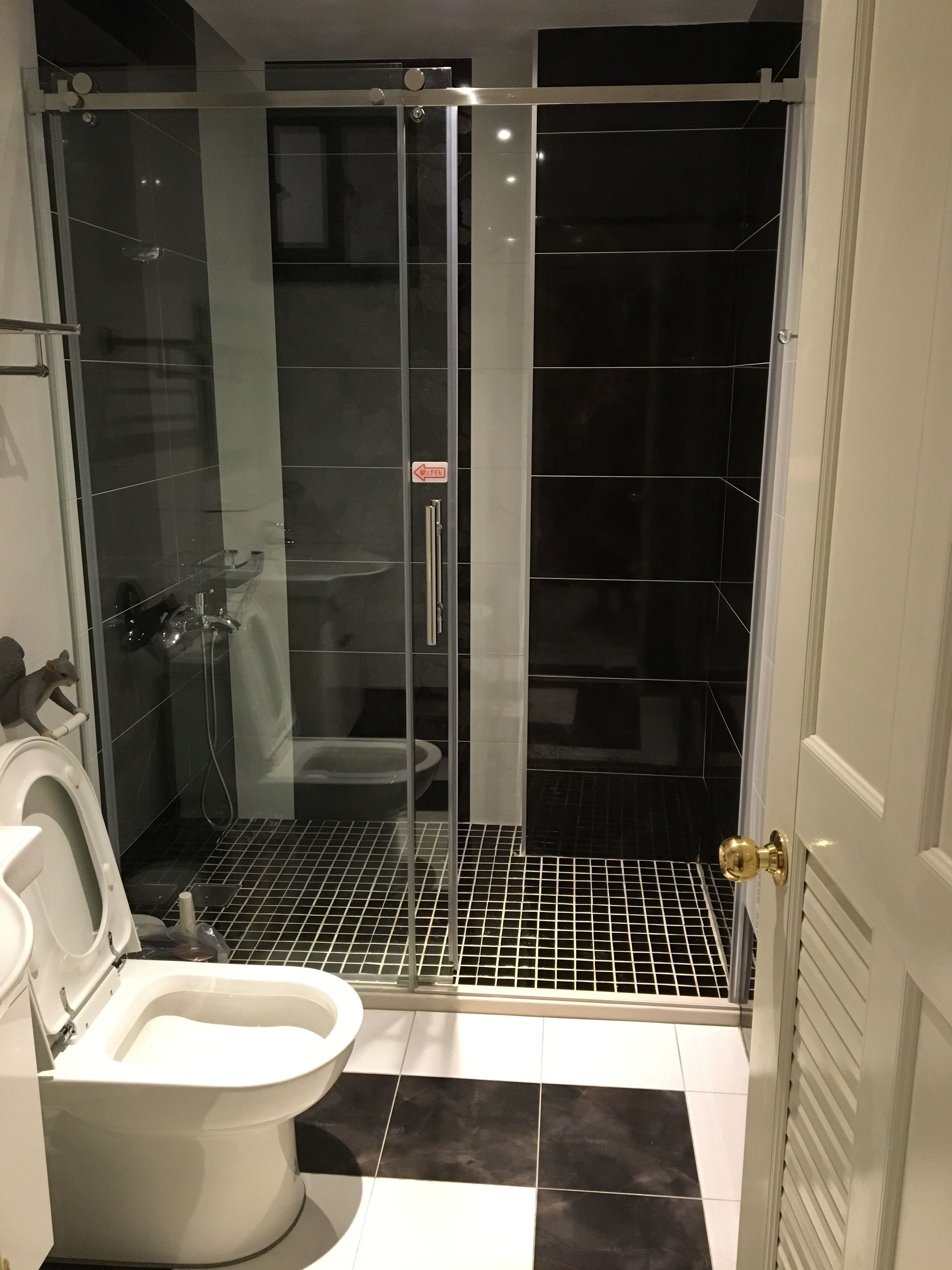 Uma casa de banho moderna com chuveiro em cabine de vidro, sanita e bidé.