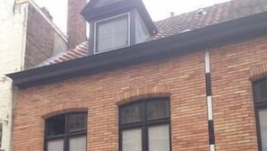 A brick building with multiple windows and a door. - Tripel B (Bruges)
