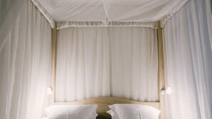 A bed with a canopy, two pillows, and a wooden headboard. - Tripel B (Bruges)