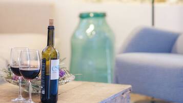 A wooden table with a bottle of wine and two glasses on it.