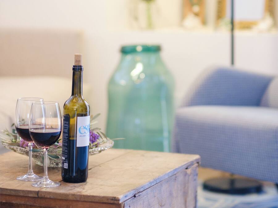 A wooden table with a bottle of wine and two glasses on it.