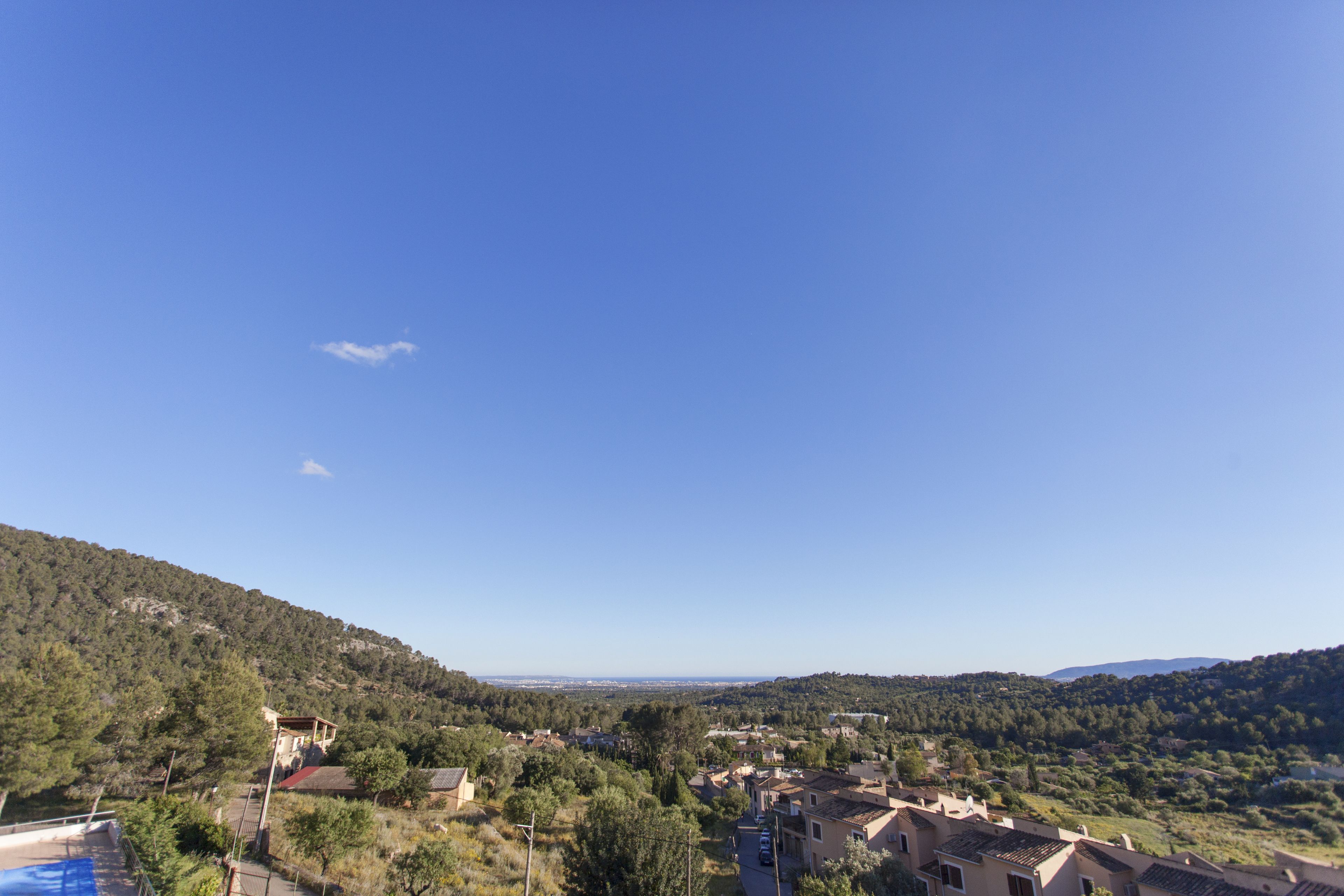 Zona residencial con casas, cielo azul despejado y un paisaje montañoso.