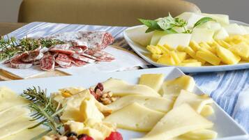 Una mesa con diversos alimentos, como queso, frutas y nueces.