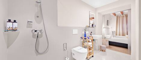 A modern bathroom with a shower, toilet, and sink.