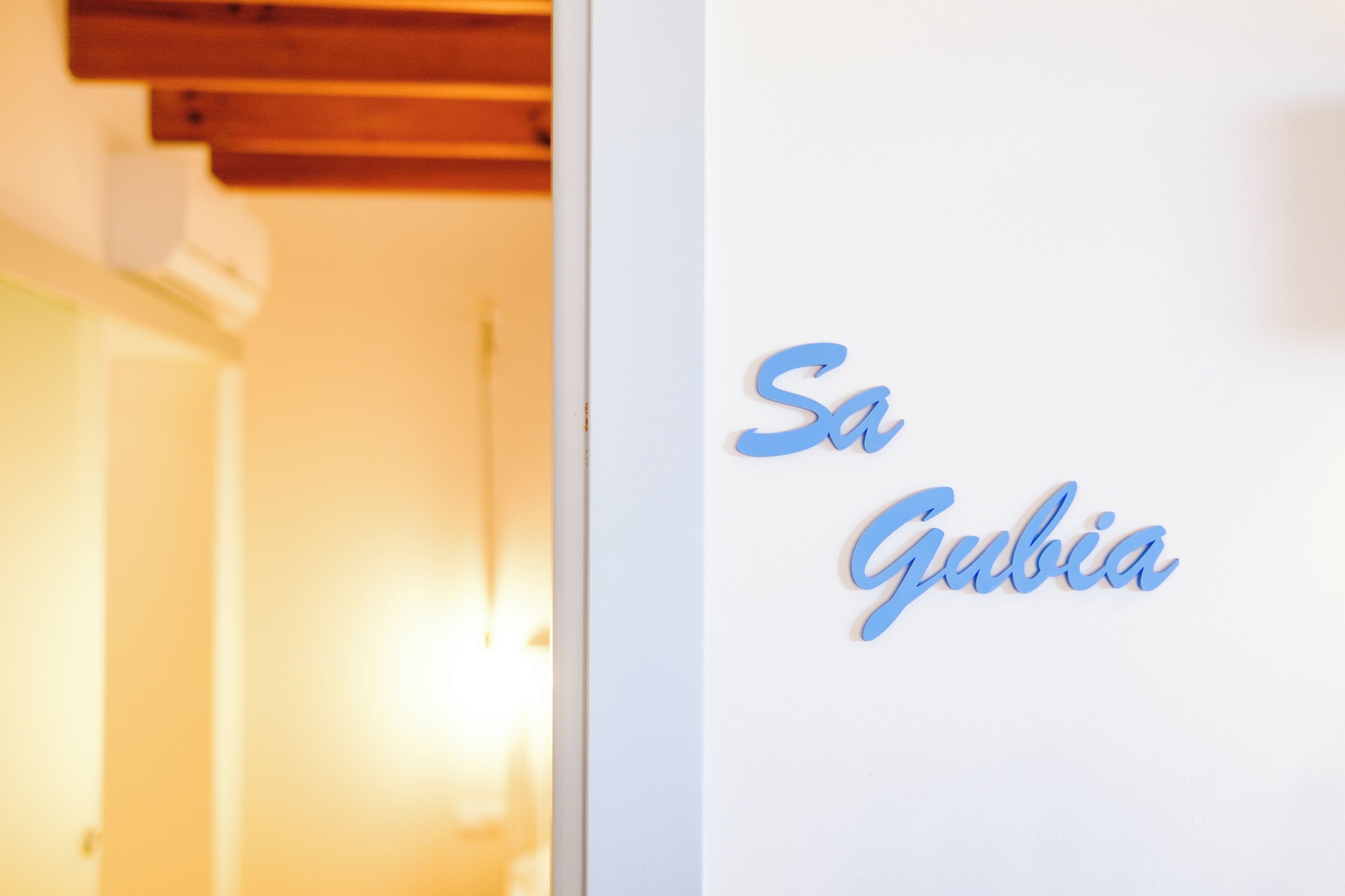 A white wall with the name "Sa Gubia" in blue lettering.