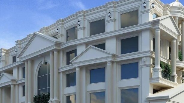 Un edificio de varios pisos con estilo arquitectónico clásico, que presenta amplias ventanas y columnas.