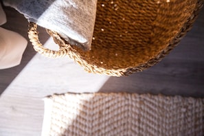 A woven basket with a handle, placed on a wooden surface. - Suites del Arenal Olehousing (Seville)