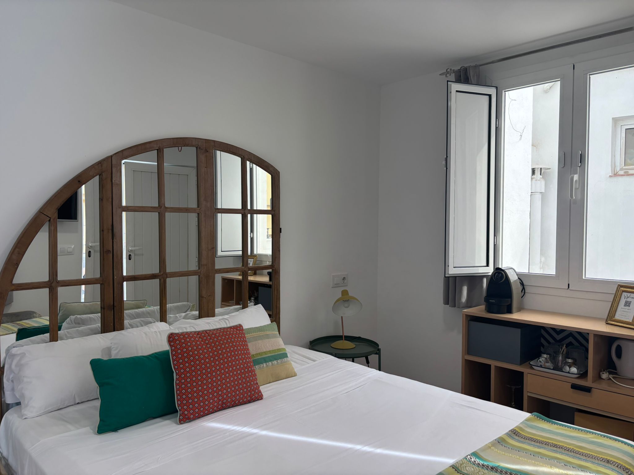 Un dormitorio con cama, escritorio, silla, lámpara y ventana.
