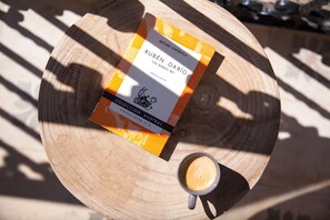 A book titled "RUBÉN DARÍO" and a cup of coffee on a wooden table. - Suites del Arenal Olehousing (Seville)