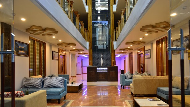 A spacious lobby with a reception desk, sofas, and a staircase. - Tara Phendeyling Hotel (Thimphu)