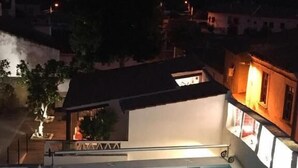 A swimming pool with a view of the surrounding neighborhood at dusk.