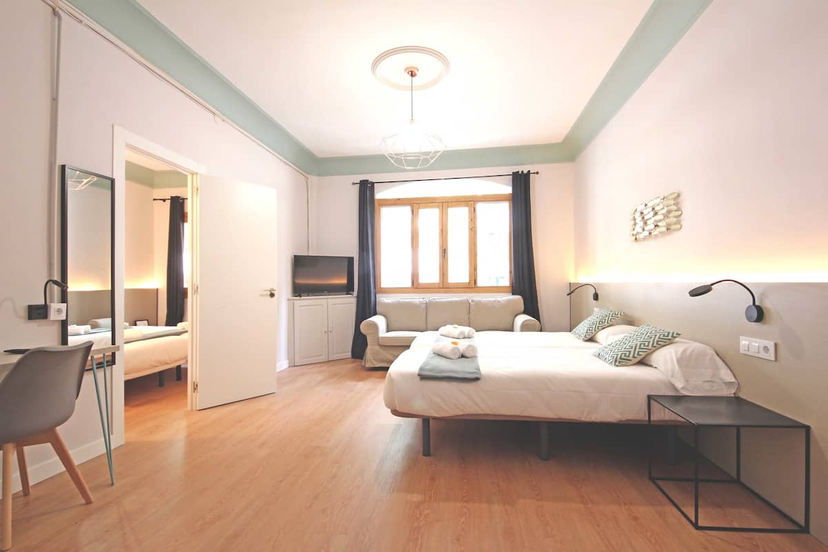 Une chambre à coucher moderne avec un lit, des tables de chevet, un bureau et une chaise.