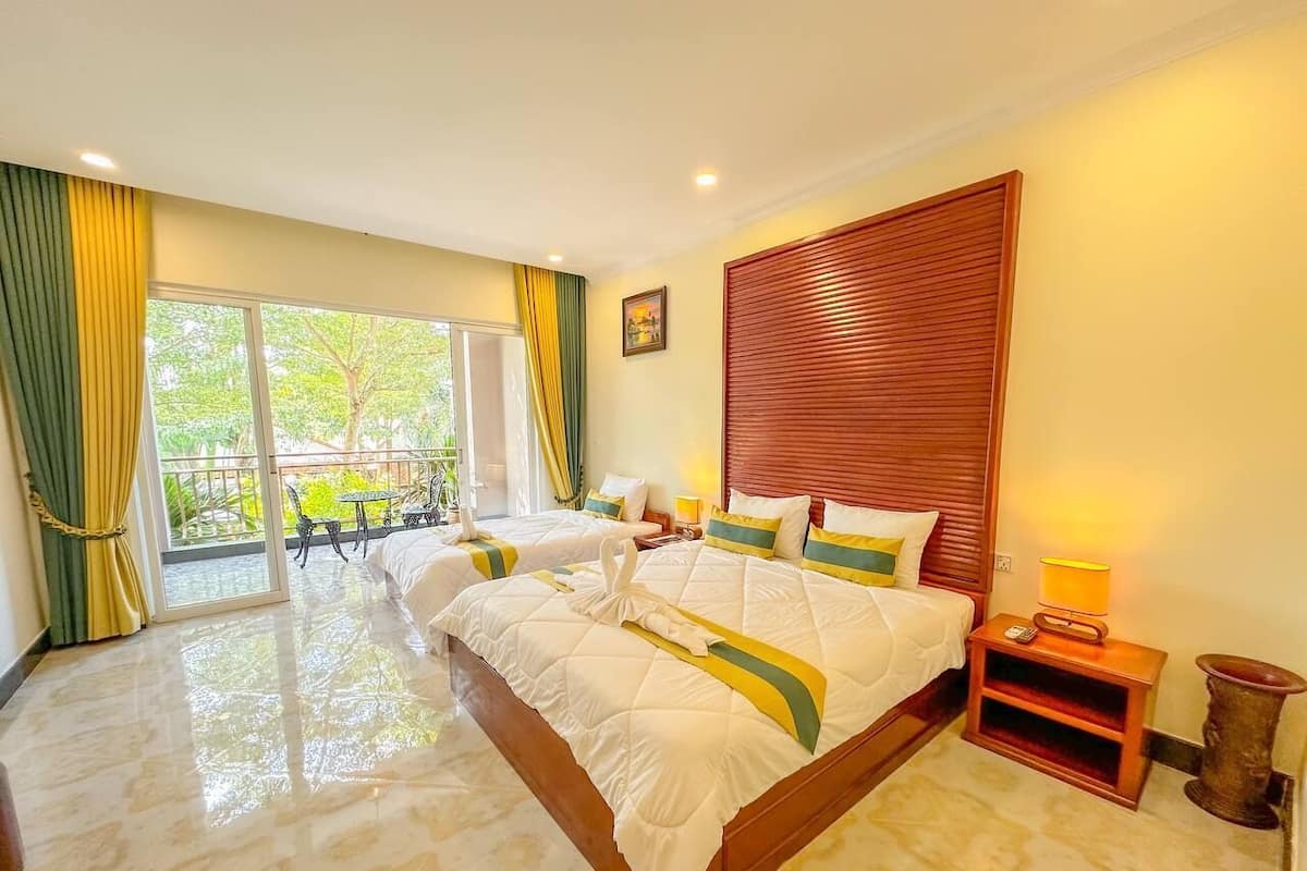 Camera d'albergo con un letto grande, un balcone e una testiera in legno.