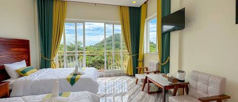 Habitación de hotel con dos camas, televisión, escritorio y una silla.
