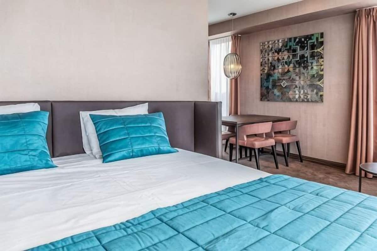 A hotel room with a bed, a desk, and a chair.
