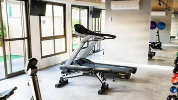A gym with exercise equipment, including a treadmill and weightlifting stations.
