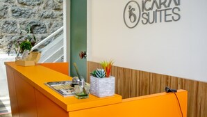 A reception desk with a sign for "ICARA SUITES" and a staircase in the background. - Icarai Suites (Niteroi)