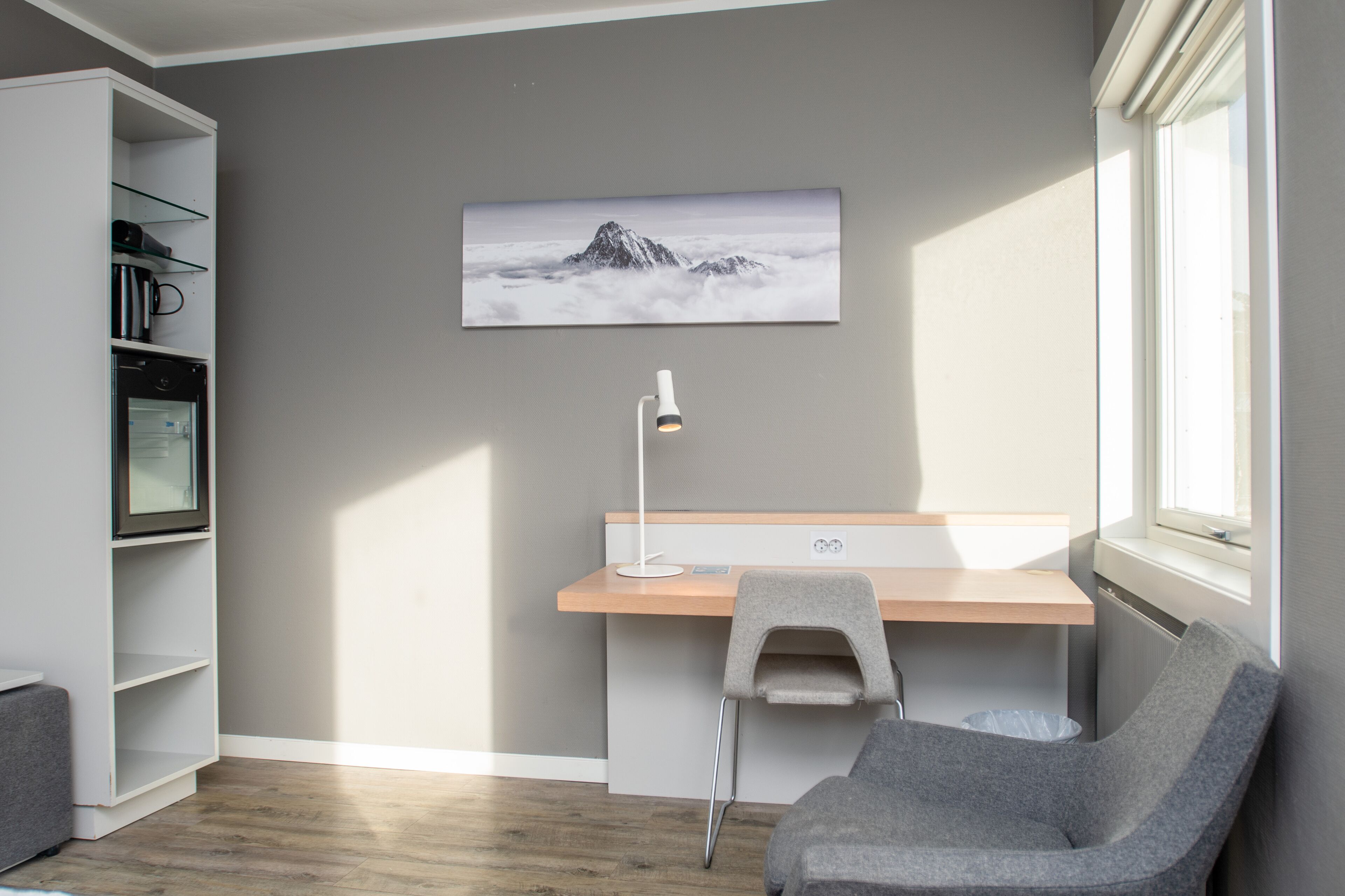 A modern room with a desk, chair, and a bookshelf.