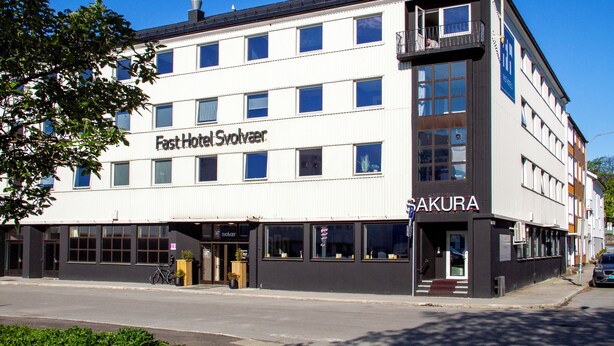 A multi-story building with a sign for 'Fast Hotel Svolvær' and 'SAKURA' on the side.