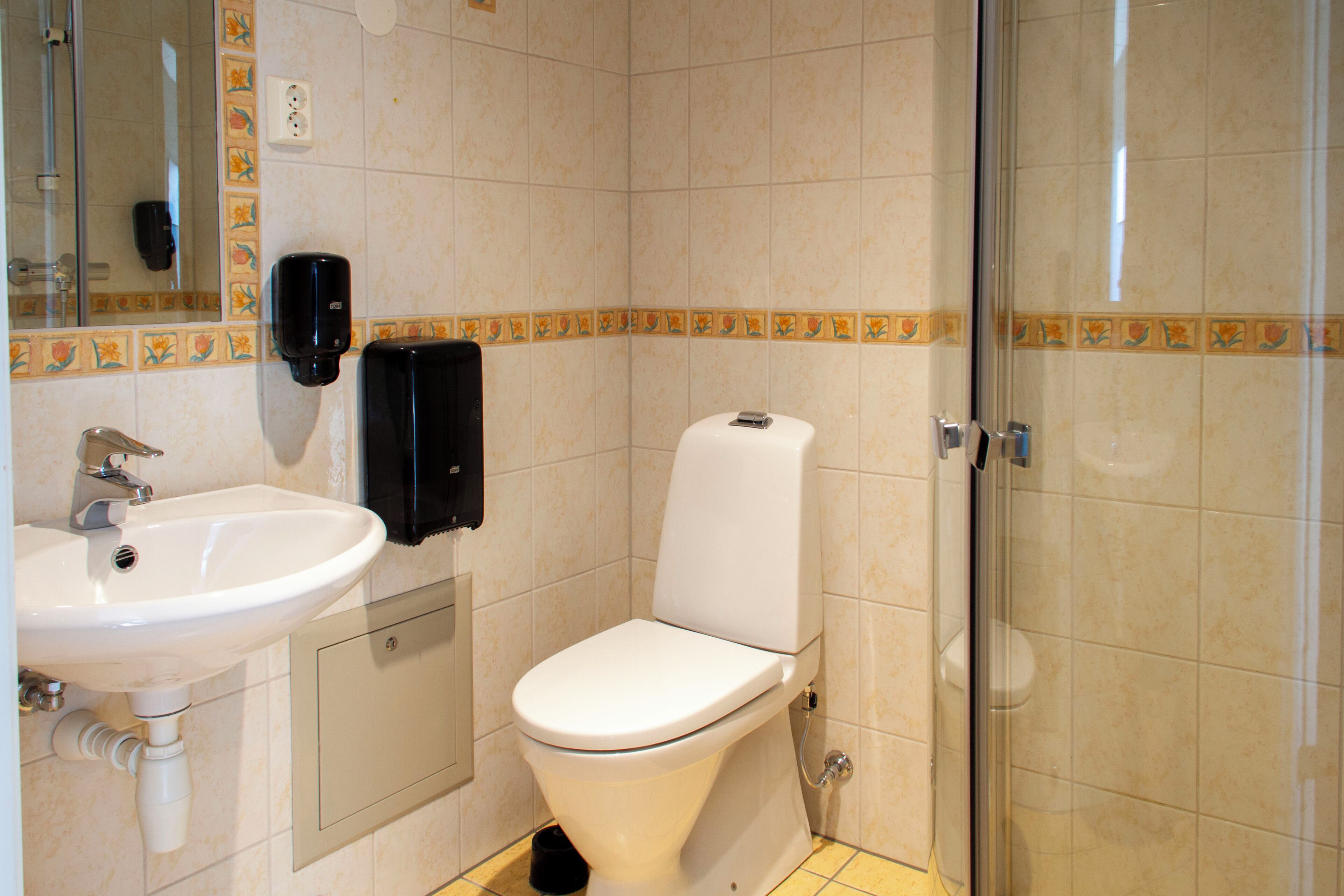 A bathroom with a sink, toilet, and shower.