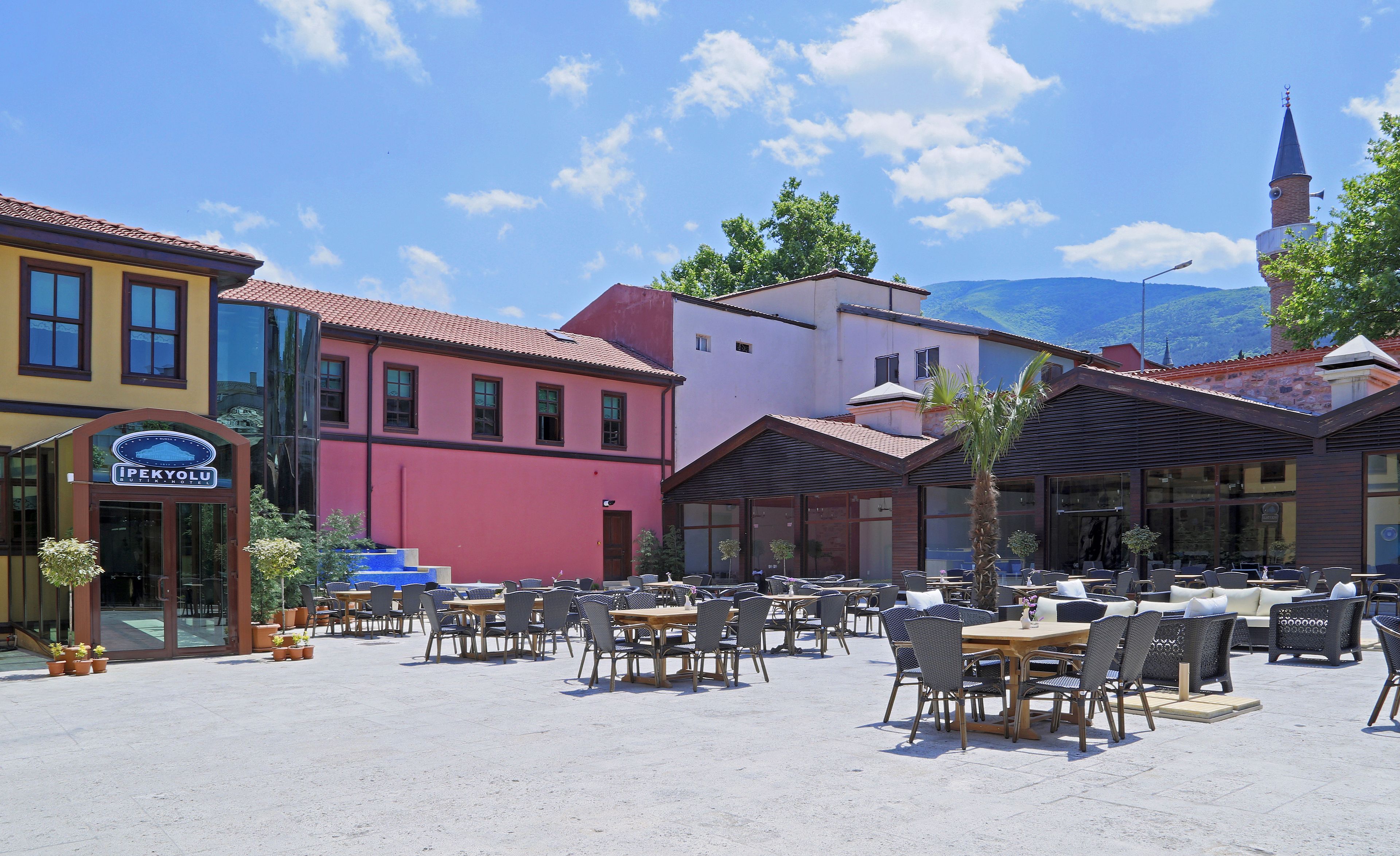 A hotel with outdoor seating and a sign reading "Ipekolu Hotel".