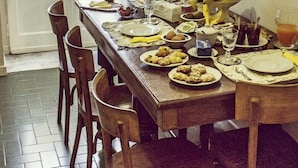 A dining table set with plates, bowls, and a fruit bowl.