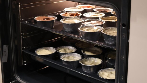 Un horno con varias bandejas de comida.