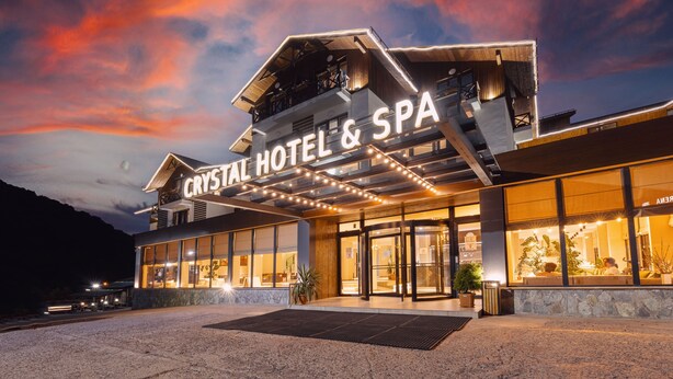 Un hôtel au design moderne, avec une enseigne bien visible indiquant « Crystal Hotel & Spa ».