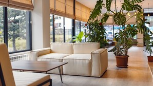 Un intérieur moderne avec un canapé beige, une table en bois et des plantes en pot.