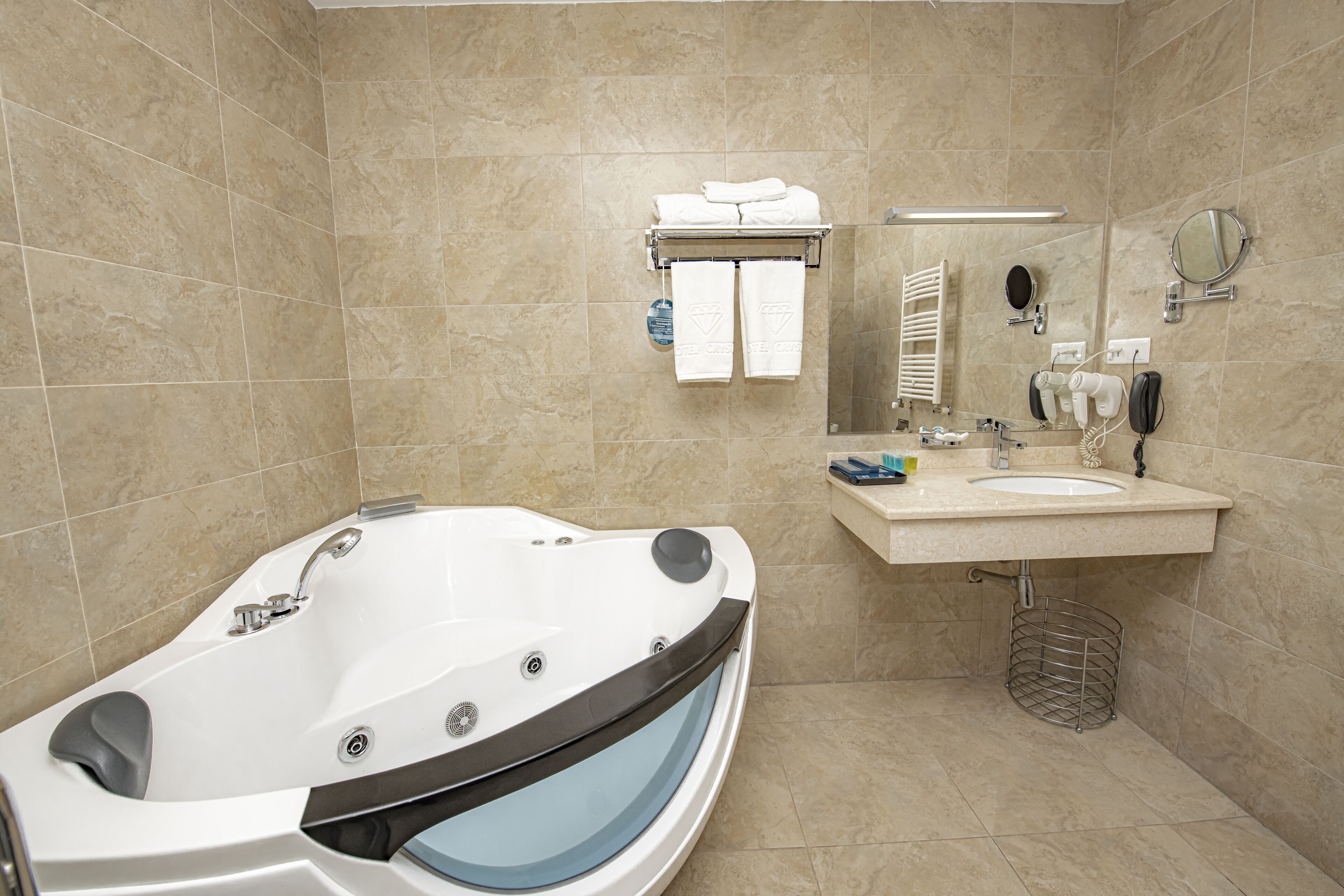 Une salle de bain moderne avec une baignoire sur pieds, un meuble-lavabo avec un évier, un miroir et un porte-serviettes avec des serviettes.